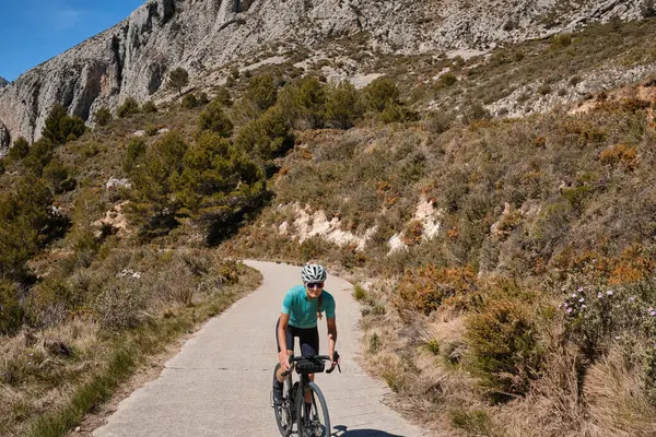 Kvinnlig Cyklist Klättrar Bergsväg Gruscykel Bär Ett Cykelkit Och Hjälm — Stockfoto