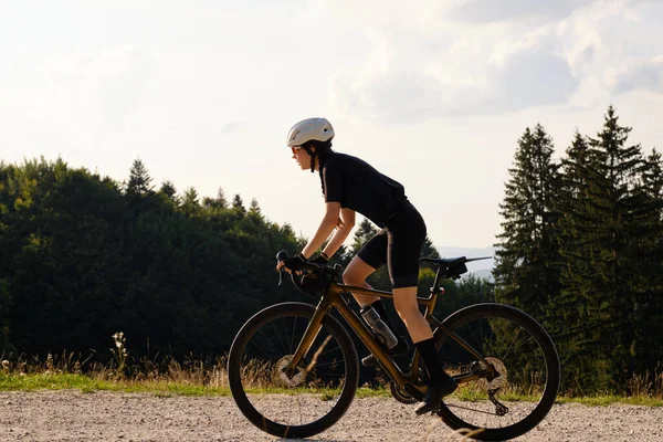 Женщина Велосипедистка Чёрном Велосипедном Комплекте Едет Велосипеде Дороге Закате Видом — стоковое фото