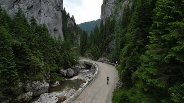 山間を走る女性サイクリスト バギリ自然公園でのグラベルバイクの冒険 サイクリングキットを着て白いヘルメットを着た女性のサイクリストは 砂利の道でトレーニングしています — ストック動画