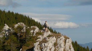 Aktif kadın dağa tırmanıyor. Dağın tepesinden doğa manzarasına hayran bir kadın sonbahar seyahatinin tadını çıkarıyor. Yürüyüş. Rahatla, doğa özgürlüğü. Dağlarda yürüyüş yapan.
