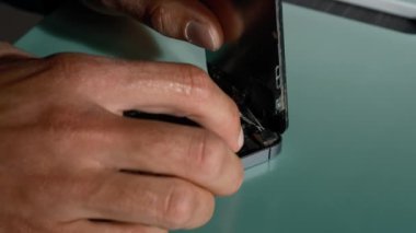 Yakın plan çekimde cep telefonu tamirini gösteriyor. Teknisyen telefonu tamir ediyor. Akıllı telefonu tamir ediyorum ve cep telefonu detaylarını güncelliyorum. Parçalanmış cep telefonu. Bir akıllı telefonun iç bileşenleri.