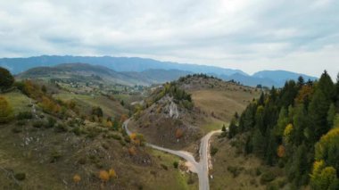 Transilvanya 'nın Sirnea köyündeki renkli tepelerin üstündeki sonbahar hava manzarası. Dağlık bölgede kırsal alan. Sonbahar manzarası. Resimli, renkli ağaçlar ve kayalık tepeler. Karpatlar dağları