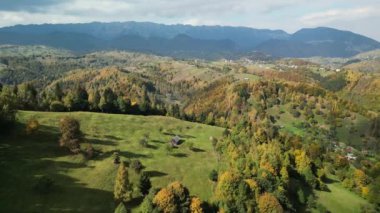 Romanya 'nın Piatra Craiului kentinde, Ulusal Park' taki güzel dağ zirveleri üzerinde renkli ormanlar ve tepeler üzerinde uçan bir dron. Parlak sonbahar yeşilliği Dağlarda sonbahar mevsimi.