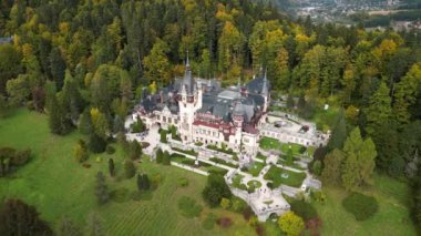 Roma 'daki Peles Kalesi' nin hava aracı görüntüsü. Karpatlar 'da bahçeler ve turistlerle dolu bir kale. Romanya 'nın Transilvanya kentindeki Sinaia kentindeki büyük bir şatonun panoramik manzarası.