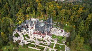 Sonbaharda Sinaia 'daki Peles Kalesi' nin insansız hava aracı videosu. Peles Castle 'ın panoramik ve manzaralı videosu. Karpatlar 'ın dağlarında bahçeli ve turistli bir kale. Romanya