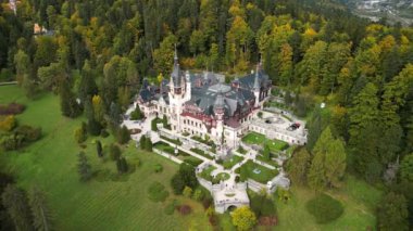 Sonbaharda Sinaia 'daki Peles Kalesi' nin insansız hava aracı videosu. Peles Castle 'ın panoramik ve manzaralı videosu. Karpatlar 'ın dağlarında bahçeli ve turistli bir kale. Romanya