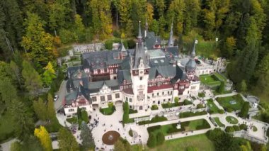 Roma 'daki Peles Kalesi' nin hava aracı görüntüsü. Karpatlar 'da bahçeler ve turistlerle dolu bir kale. Romanya 'nın Transilvanya kentindeki Sinaia kentindeki büyük bir şatonun panoramik manzarası.