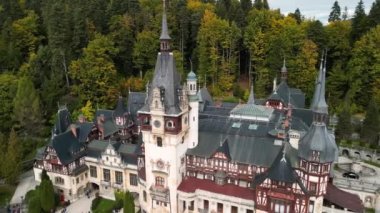 Roma 'daki Peles Kalesi' nin hava aracı görüntüsü. Karpatlar 'da bahçeler ve turistlerle dolu bir kale. Romanya 'nın Transilvanya kentindeki Sinaia kentindeki büyük bir şatonun panoramik manzarası.