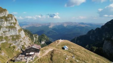 Romanya 'nın Bucegi dağlarındaki Caraiman dağ evinin hava görüntüleri. Cabana Caraiman. Eski ahşap dağ evi bir dağ yamacına kurulmuş. Bucegi Doğal Parkı. Transilvanya..
