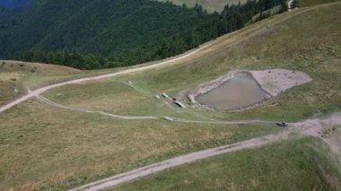Atletik erkek, havalı dağ bisikletiyle yokuş aşağı hızla iniyor. Dağ yolunda dağ bisikleti süren adamlar. Kır bisikletçileri. Dağ bisikleti yolu. Enduro bisikleti. Azuga, Romanya