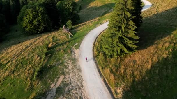 Nagranie Drona Samicy Rowerzystki Jadącej Żwirową Drogą Między Górami Zachodzie — Wideo stockowe