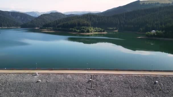 ルーマニアのボルボシ湖とダムの空中ドローンビュー 湖の近くのダムに沿ってサイクリストに続くドローン バギリ — ストック動画