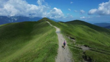 Romanya 'nın Karpat Dağları' nda yürüyüş yapan bir kadın turist Bucegi Doğal Parkı manzarasının keyfini çıkarıyor. Drone seyahati sırasında bir kadını takip ediyor. Dişi gezgin.