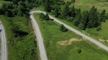 Dişi bisikletçi dağlardaki çakıllı yolda bisiklet sürüyor. Sporcu hedefe ulaşmak için çaba sarf ediyor. Seyahat ve spor kavramı. Etkin yaşam biçimi.