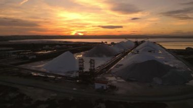 Güzel altın gün batımında işletim araçlarıyla birlikte açık hava tuz madeni. Hava aracı görüntüleri, yörünge hareketi. Fabrica del Sal, Torrevieja, İspanya