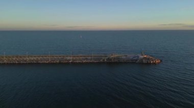 İskeleli ve deniz fenerli İHA görüntüleri, İHA 'lar sola kayıyor. Sakin bir akşam atmosferi, Torrevieja, İspanya