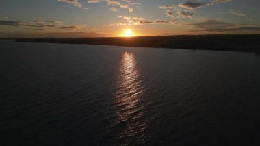 Sahilde güzel bir gün batımı. Denizin üzerinde sarı güneş. Turuncu renk dalgaları. Doğa geçmişi. Güzel sakin bir sahne. Güneş ışığı su yüzeyine yansıyor.