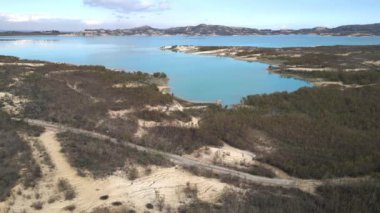 Göl boyunca bir bisikletlinin sürdüğü Mumyalama de la Pedrera 'nın kuş bakışı görüntüsü.