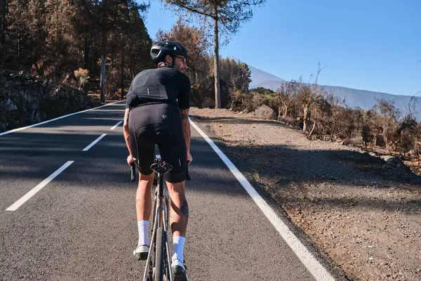 Erkek bisikletçi, Tenerife, Kanarya Adaları, İspanya 'daki Teide volkanı manzaralı yolda pedal çeviriyor. Sporcu dışarıda bisiklet eğitimi alıyor. Liman motivasyonu. Açık havada bisiklet eğitimi. Hippi bisikletçi..