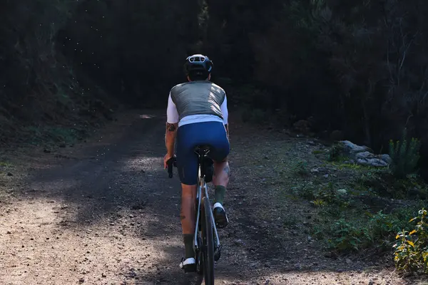 Arka planda, Tenerife, Kanarya Adaları 'ndaki ormanda çakıllı bisiklet süren erkek bisikletçinin görüntüsü var. Spor motivasyonu. İspanya 'da bisiklet eğitimi. Bisiklet macerası .