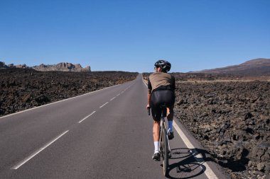 Bisikletli adam Tenerife, Kanarya Adaları, İspanya 'daki Teide Dağı volkanı manzaralı yolda pedal çeviriyor. Sporcu dışarıda bisiklet eğitimi alıyor. Liman motivasyonu. Açık havada bisiklet eğitimi. Hippi bisikletçi..