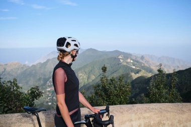 Anaga Park, Tenerifede bisiklet süren bir kadın. Dağ yolu bomboş. Spor motivasyon görüntüsü. Güzel doğada bisiklet sürmek. Bisikletçi bisiklet takımı ve kask takıyor.