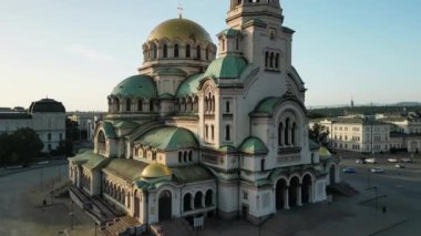 Bulgaristan 'daki St. Alexander Nevsky Katedrali' nin insansız hava aracı görüntüleri. Gün doğumunda yeşil ağaçlarla çevrili Bulgar ortodoks kilisesi. Ortodoks katedrali. İHA 'dan uçmak.