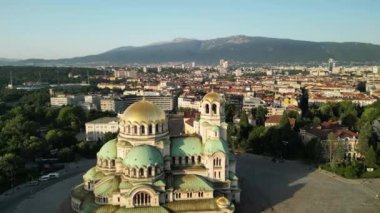 Bulgaristan 'ın Sofya kentindeki St. Alexander Nevsky Katedrali' nin insansız hava aracı görüntüsü. Güneş doğarken yeşil ağaçlarla çevrili ikonik Bulgar ortodoks kilisesinin görüntüleri.