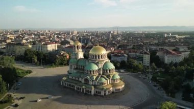 Bulgaristan 'daki St. Alexander Nevsky Katedrali' nin insansız hava aracı görüntüleri. Gün doğumunda yeşil ağaçlarla çevrili Bulgar ortodoks kilisesi. Ortodoks katedrali. İHA 'dan uçmak.