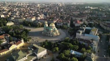 Bulgaristan 'ın Sofya kentindeki St. Alexander Nevsky Katedrali' nin insansız hava aracı görüntüsü. Güneş doğarken yeşil ağaçlarla çevrili ikonik Bulgar ortodoks kilisesinin görüntüleri.