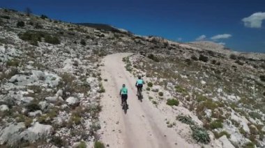 Dağların manzaralı güzelliğinde çakıl bisikleti süren bisikletçilerin robot görüntüsü. Çakıl taşlı yollarda ya da off-road 'larda bisiklet sürmek. Aktif maceralar ve bisikletle seyahat kavramı. Doğada çakıl bisikleti sürmek.