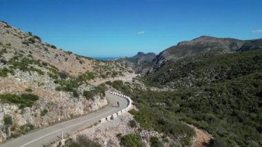 Dağlarda bisiklet süren kadın yol bisikletçisinin hava aracı görüntüsü. Bisiklet ve triatlon konsepti sporcular için sağlıklı açık hava yaşam tarzı. Doğada bisikletçilik. Açık havada antrenman. Bisiklet eğitimi.