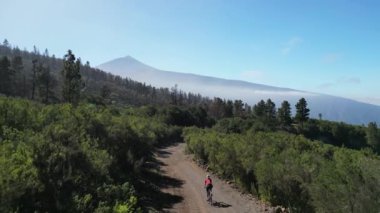 Uçağı çeken kadın bisikletçi Tenerife, Kanarya Adası, İspanya 'da çakıllı yolda çakıl bisikleti sürüyormuş. Çakıl bisikleti macerası. Aktif bisiklet yolculuğu kavramı.