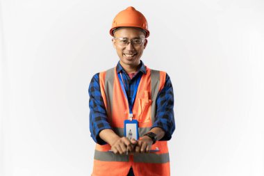 Güvenlik teçhizatı takan Asyalı erkek inşaat işçisi elinde bir dosya, saha müfettişi, endüstriyel ve inşaat konsepti, izole edilmiş beyaz arka plan taşırken kameraya güvenle bakıyor..
