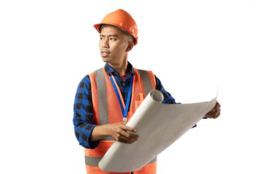 Genç Asyalı erkek inşaat işçisi, sanayi ve inşaat konseptlerinden oluşan bir parşömen açıyor, izole beyaz arka plan.