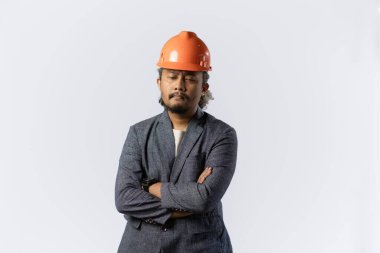 İyimser erkekler ifadeleri ve jestleri düşünür. Beyaz arka planda turuncu kasklı takım elbiseli şık Asyalı bir adam. inşaat ya da madencilik konsepti fotoğrafı