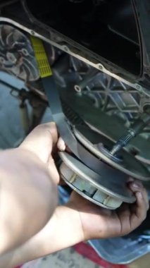 Motosiklet motoru silindirini temizleyen bir adam. Tamircinin elleri motorsiklet parçalarını temizliyor