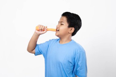 Asyalı çocuklar havuç yer beyaz arka plan