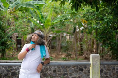 Kıvırcık Asyalı Endonezyalı adam egzersiz yapmaktan yoruldu. 