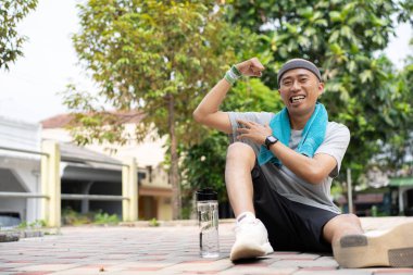 Kel bir Asyalı sabah elinde içki kadehiyle koşarken kendinden emin ve mutlu görünür..