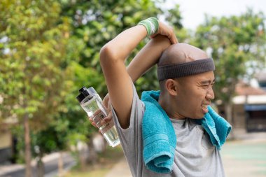 Endonezyalı Asyalı adam sabah koşusundan önce ısınıyor. Sağlıklı yaşam tarzı kavramı.