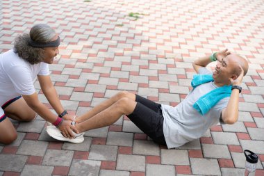 Endonezyalı adama mekik çekerken arkadaşı tarafından yardım ediliyor. Sağlıklı yaşam tarzı kavramı egzersiz yapmaktır..