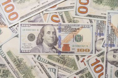 Bir yığın dağınık dolar, para, doku ve geçmişin üstüne 100 dolarlık banknot..