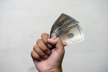 Erkek el sıkışması 100 Amerikan doları, para birimi konsepti, gri arka planda izole edilmiş..