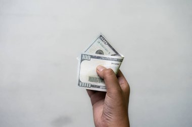 Erkek el ele tutuşan dolar, para birimi konsepti, gri arka planda izole edilmiş..