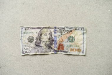 100 dolarlık buruşuk bir banknot, para birimi konsepti, gri arka planda izole edilmiş..