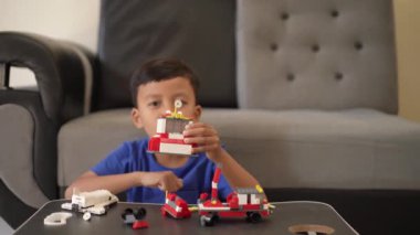 Evde oynarken oyuncak monte eden Endonezyalı bir çocuğun portresi.