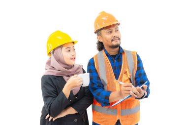 Genç Endonezyalı kadın patron tesettür ve güvenlik kaskı takıyor. Bir fincan kahve taşırken inşaat işçilerinin raporuna bakıyor. Kadın patron ve endüstri kavramı, beyaz üzerine izole edilmiş.