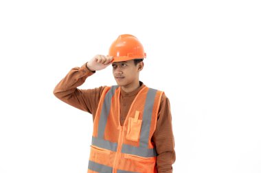 Endonezyalı genç erkek inşaat işçisi, güvenlik şapkası takıyor işten önce, endüstriyel ve inşaat konsepti, beyaz arka planda izole edilmiş.