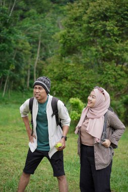 Endonezyalı genç kadın gezginler tesettür ve erkek gezginler dinleniyor doğada seyahat ederken, seyahat konsepti.